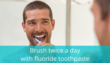 young man looking happy brushing his teeth through the mirrow
