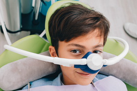 children boy patient being safely sedated with laughing gas or nitrous oxide by dentist in Glebe, NSW 2037.
