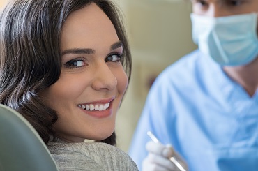 female patient smiling at the doctor's chair before her dental treatment at our dental clinic in Glebe, nearby Sydney CBD.