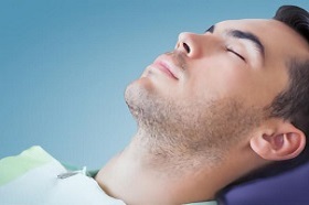 male patient sleeping after IV Sedation on the dentist chair at Dental Care Glebe Sleep Dentistry