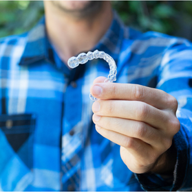 Invisalign Adults, man showing his clear aligners on his hands